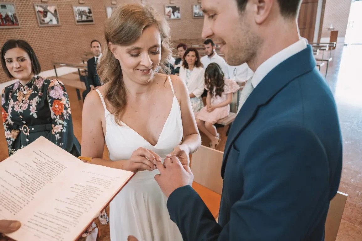 Poročna fotografija mladoporočencev; ujet pristen trenutek z naravno svetlobo in umirjeno kompozicijo v dokumentarnem slogu.